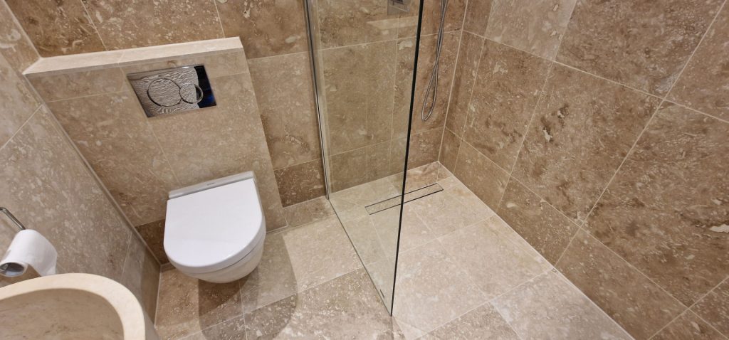 Modern bathroom installation with walk-in shower and wall tiles by bathroom fitters in Chelsea London