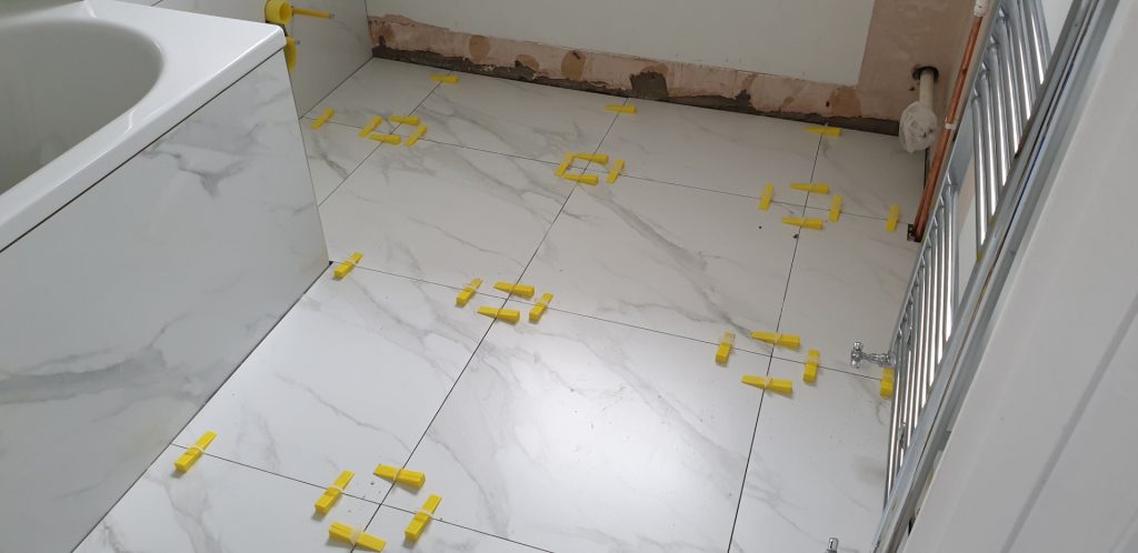 Bathroom floor tiling installation during bathroom refurbishment project