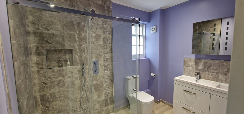 Modern bathroom refurbishment with walk-in shower, large stone tiles and vanity unit installed by Sublime Property