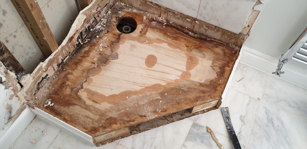 Shower leak investigation showing water damage to bathroom floor beneath a leaking shower tray in Barnes London